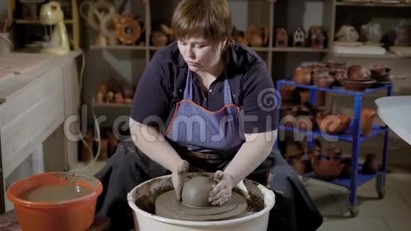 女工匠正在用陶瓷器在旋转转盘上投掷粘土坯料视频的预览图