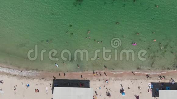 当人们行走时海浪拍打在海滩上的鸟瞰无人机镜头视频的预览图