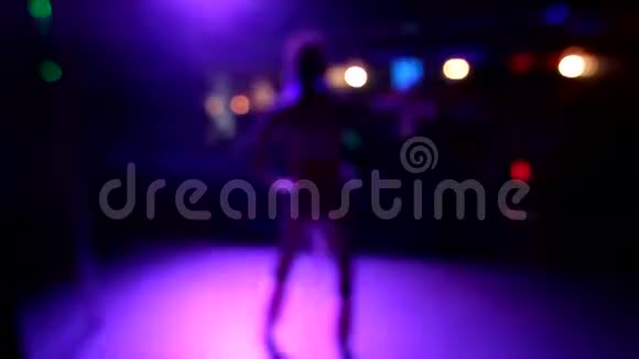 在夜总会背景模糊的舞台上跳舞的女孩彩色抽象模糊的灯光背景在的夜晚视频的预览图