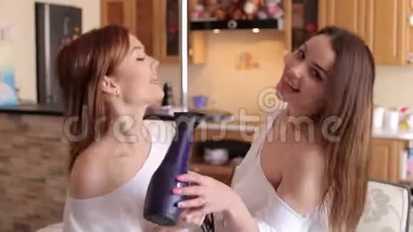 两个女孩用吹风机吹干头发唱歌视频的预览图