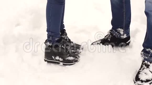 一对夫妇在公园里雪地里的特写鞋视频的预览图