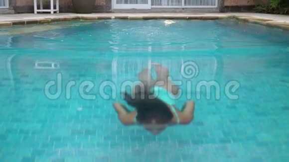 穿着天蓝色泳衣的苗条模特在私人住宅后院的游泳池里水下游泳女孩视频的预览图