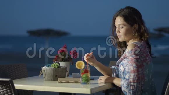 体贴的美丽的恋爱中的女士在海滩咖啡馆思念或等待某人视频的预览图