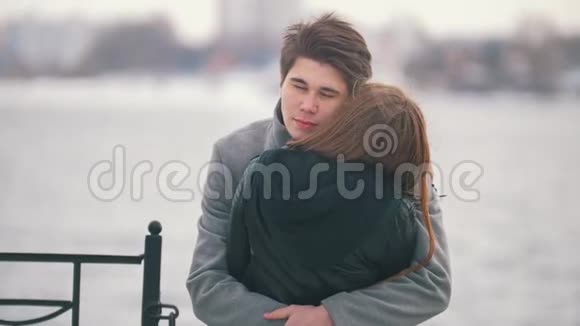 年轻人在河边的背景上拥抱他的女朋友视频的预览图