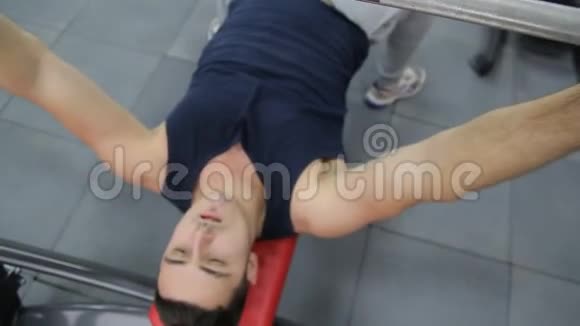 健身男子在健身房训练胸部肌肉用杠铃做平凳按压视频的预览图