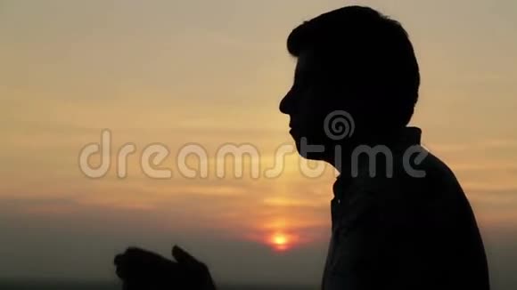 日落祈祷的年轻人视频的预览图