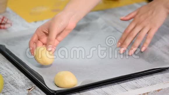 烘焙前的酵母包子用烤纸躺在烤片上烹饪过程视频的预览图