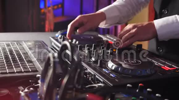 关闭DJ手播放音乐混合夜总会迪斯科派对的Dj混合机控制台DJ手触摸视频的预览图
