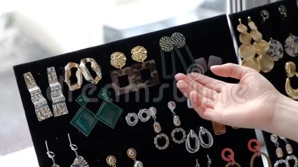 一个年轻的女人从她的收藏中选择耳环时尚珠宝美丽的配饰每天慢动作视频的预览图