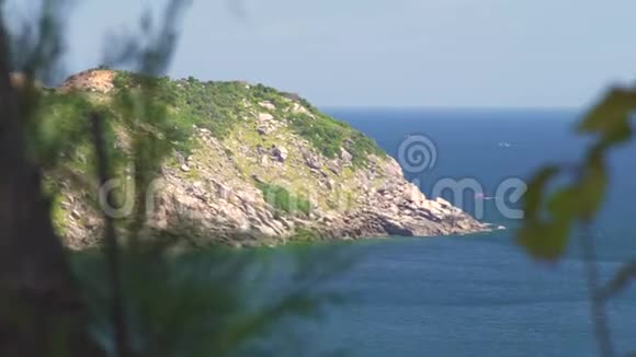 洛基岛覆盖着绿色植物和地平线上的蓝色海洋景观岛岸的海景和岩石悬崖视频的预览图