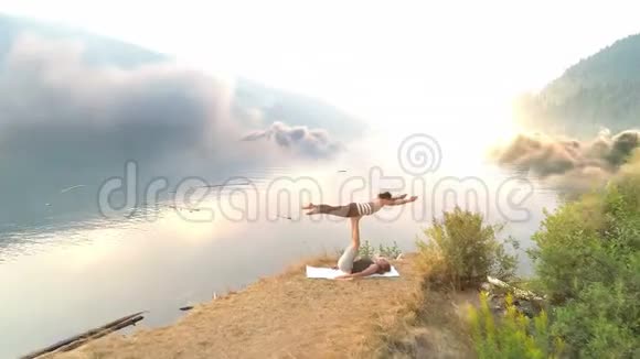 女性朋友在河山上做瑜伽视频的预览图