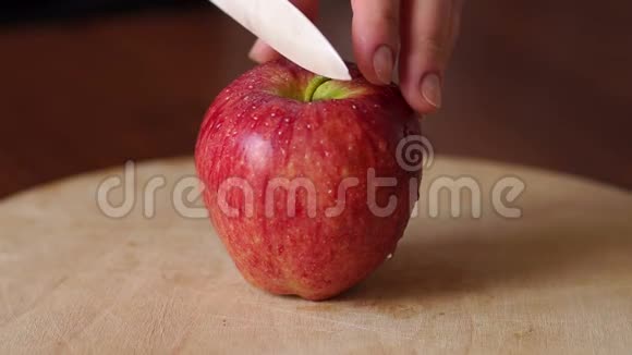 特写将红苹果切在木板上视频的预览图