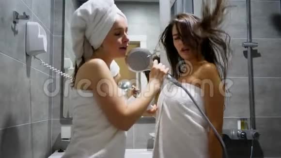 穿着浴巾的漂亮女孩在淋浴时拿着吹风机鬼混视频的预览图