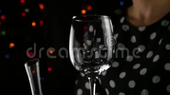 白葡萄酒装满一杯女人在黑暗中喝一杯酒节日气氛慢动作视频的预览图