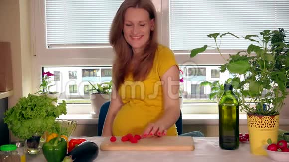 快乐的孕妇吃红浆果微笑着看着镜头视频的预览图