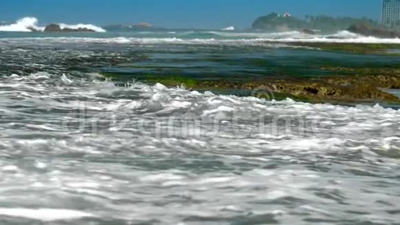 蓝色的海浪白色泡沫洗绿色海藻视频的预览图