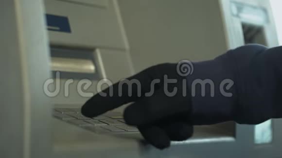 戴手套的可疑男子插入密码从银行账户偷钱视频的预览图