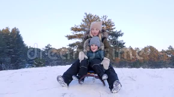 在阳光明媚的冬日里年轻的妈妈和儿子一起在新鲜空气的特写镜头里玩得很开心视频的预览图