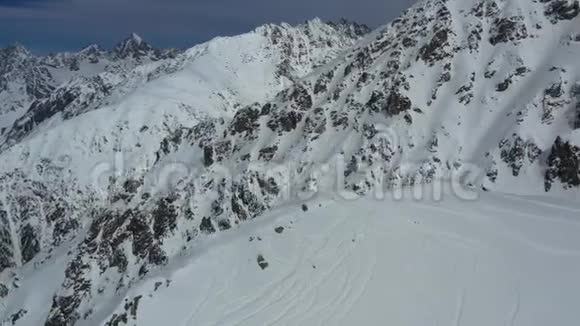 大山上覆盖着多岩石的小山雪覆盖着美丽的空中镜头4k视频的预览图