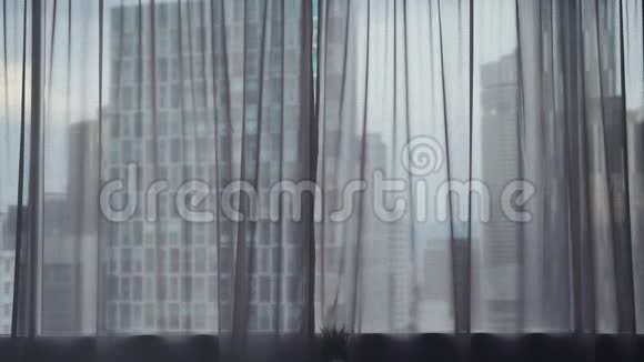 年轻苗条的黑发女人跑着打开大窗户上的窗帘伸展着手臂看着她的公寓视频的预览图