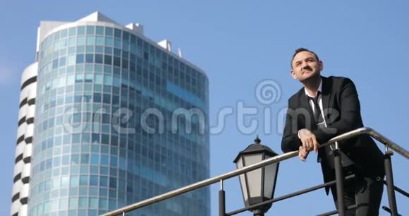 成功的商人白天眺望城市天际线一个人站在一栋大楼的顶上望着城市视频的预览图
