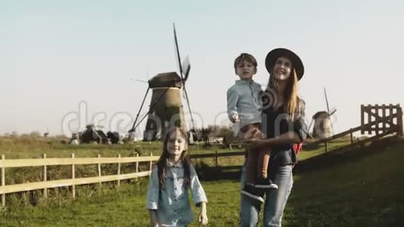 在一个风车农场附近有两个孩子的白人妇女妈妈小男孩和可爱的女孩一起探索周围的环境4公里视频的预览图
