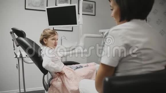 儿童牙医我办公室里的小女孩进行咨询医生和一个女孩谈论视频的预览图