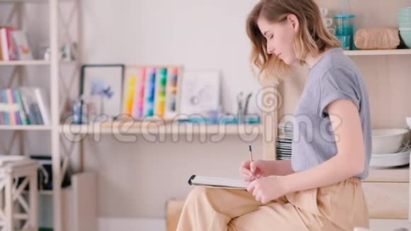 艺术家素描女人坐在家里集中注意力视频的预览图