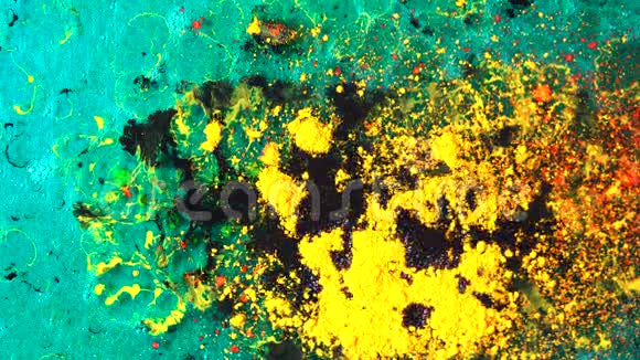 在绿松石背景上黄色干油墨被黑色液体疼痛浸泡的顶部视图混合的美丽过程视频的预览图