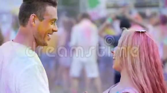 一对精力充沛的年轻夫妇身着彩色粉末随着音乐翩翩起舞面带微笑视频的预览图