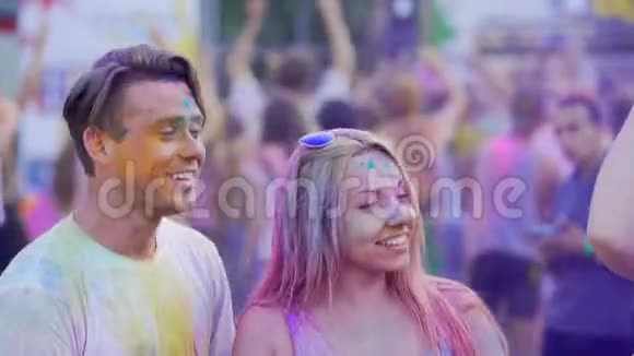 欢乐的一对情侣在聚会上成群结队地移动着音乐空中喷洒着彩色粉末视频的预览图