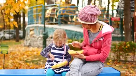 妈妈和女儿在秋天的下午在公园吃午饭爱家庭食物视频的预览图