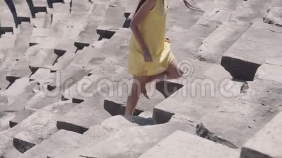 美丽的女孩在古罗马剧院的台阶上奔跑视频的预览图