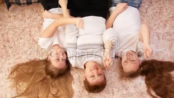 年轻女子和两名少女躺在家里的地板上玩游戏的画像视频的预览图