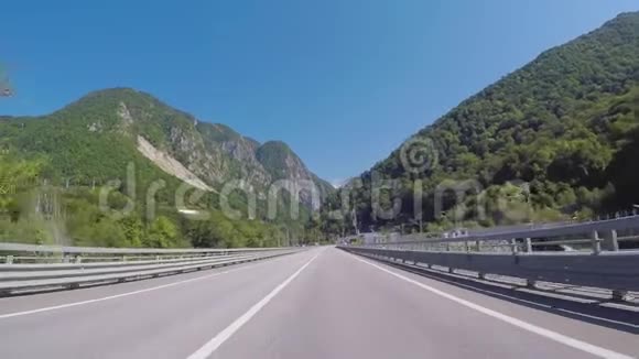 从汽车上行驶到KrasnayaPolyana的高速公路上夏天可以看到蓝天树木和高加索山脉场景视频的预览图