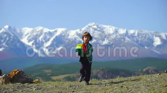 一个非常可爱的男孩在山上玩得很开心小帅哥在山顶上玩玩具车视频的预览图