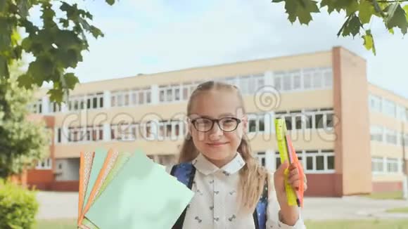 一个微笑的女学生的肖像展示笔记本和尺子开学快乐视频的预览图