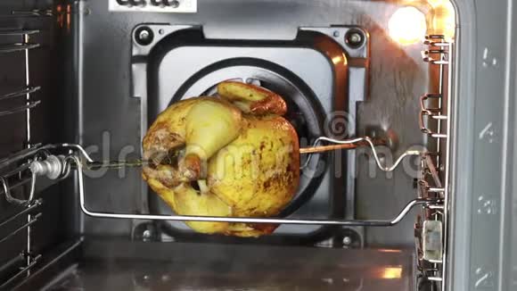 烤箱烤鸡是用唾沫煮熟的它在垂直方向上逐渐旋转视频的预览图