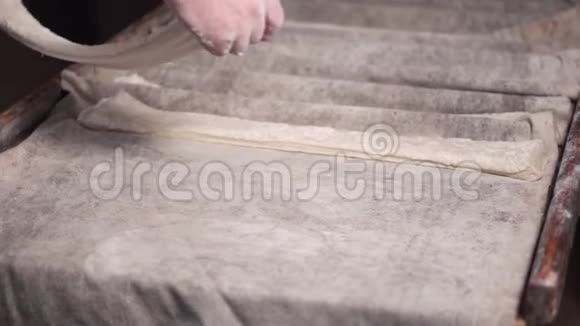 面包师在面包店生产中准备一排排未煮熟的面团面包直到下一阶段的烘焙视频的预览图