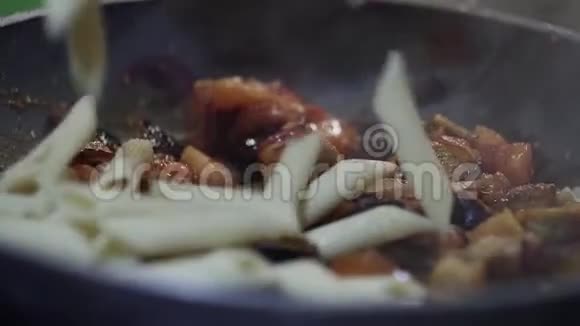 食物准备通心粉落在蒸西红柿洋葱和茄子上视频的预览图