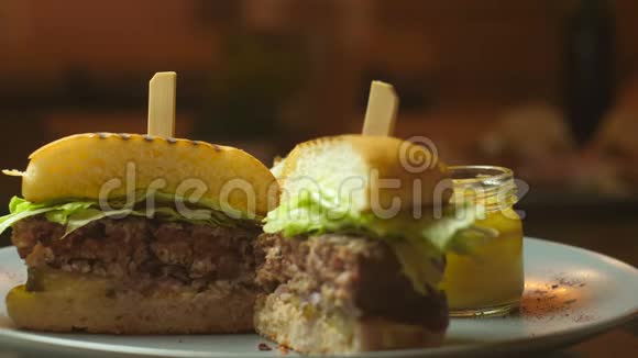 美味可口的汉堡有牛肉西红柿沙拉和酱汁在木桌和黑色背景文本或视频的预览图