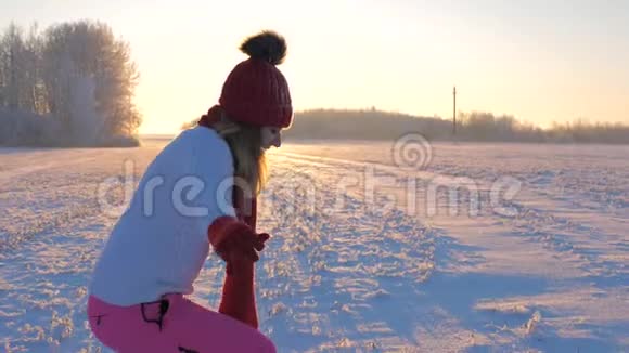 在日落时享受冬雪的女人在下着雪的时候视频的预览图