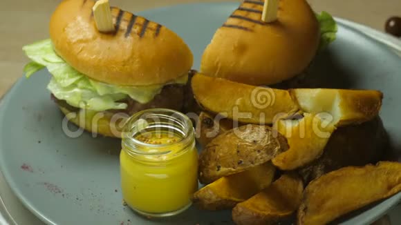 汉堡包是美味多汁的有牛肉或羊排奶酪腌制黄瓜生菜叶上面有油炸食品视频的预览图