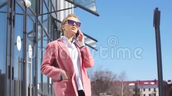 迷人的商务女性在街上和顾客交谈低角度视角时尚的外观视频的预览图