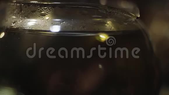 大型玻璃瓶中干燥草本植物的特写镜头落在水面上视频的预览图