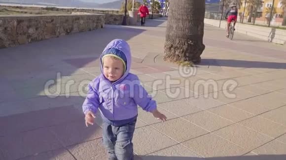 小男孩沿着海边的人行道跑视频的预览图