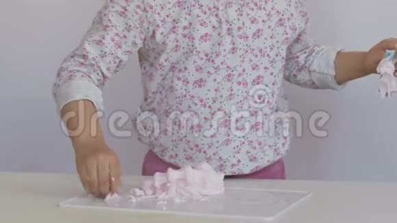 一个小女孩玩味地把面团放在她房间的桌子上视频的预览图