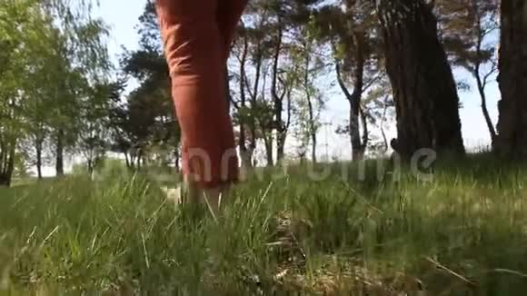 女人光着脚走过绿草地视频的预览图
