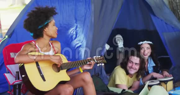 在音乐节上为朋友弹吉他的女人视频的预览图