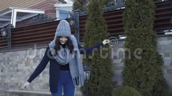 漂亮的微笑女孩穿着温暖的衣服在豪华的院子里散步4K视频的预览图
